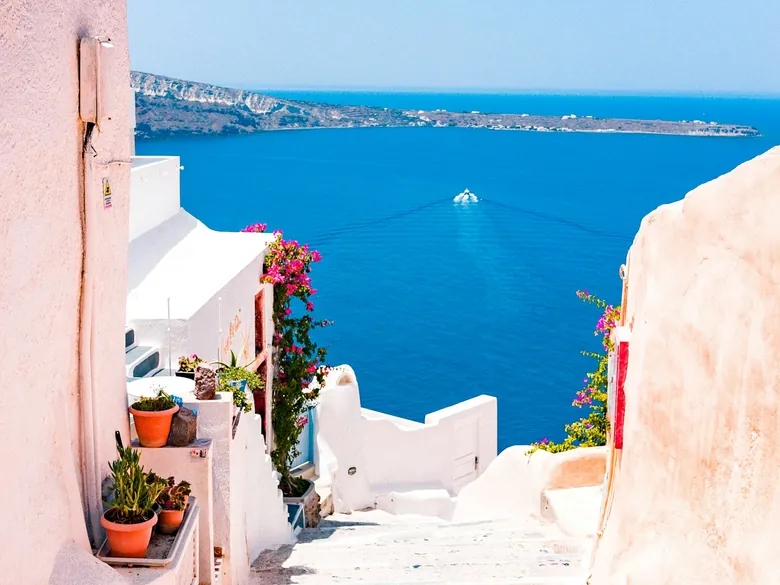 Steps leading down between pale stucco walls to the Mediterranean sea